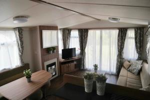拉隆德莱丝莫里斯Camping Parcvalrose Mobile Home No 79的客厅配有沙发和桌子