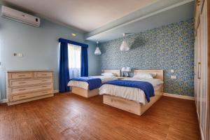 阿尔卜Aldo House的一间卧室设有两张带蓝色墙壁和木地板的床。