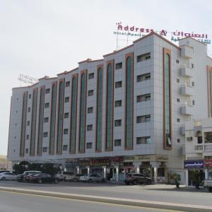 Aş Şa‘arahAddress hotel Apartments العنوان للشقق الفندقية的停车场内停放汽车的大型建筑