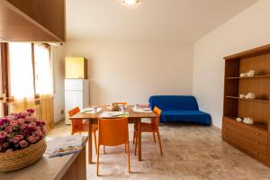 锡尔维玛丽娜Edera 2 Silvi Vacanza的厨房以及带桌子和蓝椅的用餐室