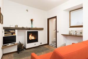多马索Casa Domaso的客厅配有橙色沙发和壁炉