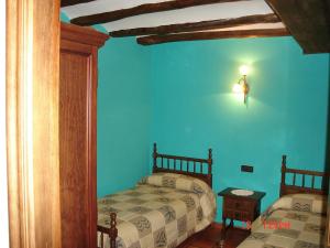 赫亚德亚尔瓦拉辛Apartamentos el Portal的一间卧室设有两张床和蓝色的墙壁