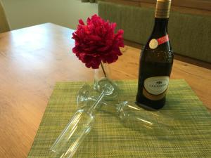 奥贝朴菲斯科菲勒尔公寓的一瓶葡萄酒和一朵红花在桌子上