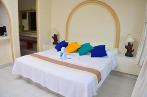 锡瓦塔塔内霍Arena Suites的卧室配有白色的床和色彩缤纷的枕头