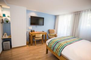 沃韦拉夏洛旅馆的一间卧室配有一张床、一张书桌和一台电视