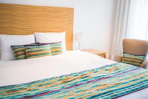 沃韦拉夏洛旅馆的一张带彩色条纹毯子和枕头的白色床