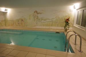 阿拉巴拜塔安缇里亚酒店的墙上挂有壁画的大型游泳池