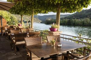 摩泽尔河畔的泽尔Hotel garni "Café im Hamm"的桌椅,享有湖景