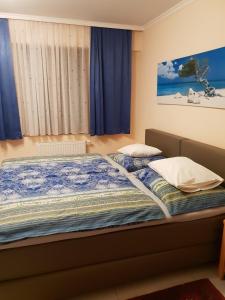 维也纳普罗索花园膳食公寓的一间卧室配有2张蓝色窗帘
