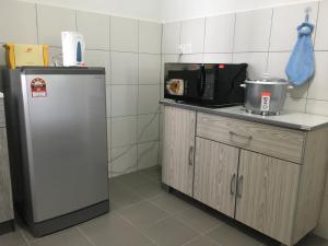古晋OHANA Sky Villa Residences的厨房配有冰箱和微波炉