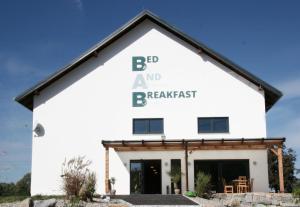 海格-安豪斯奥克Bed & Breakfast的白色的建筑,有bc字,朝东反应