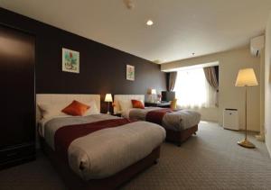 Matsuyama紫雲閣东松山花园酒店的酒店客房设有两张床和窗户。