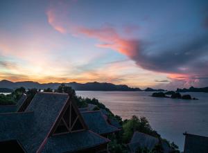 珍南海滩Sari Village Jungle Retreat的享有日落和水面的景色