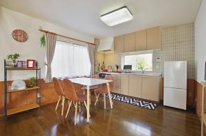 伊豆Villent Fujimi Hiekawa的厨房配有桌椅和冰箱。
