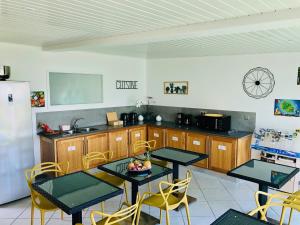 圣皮埃尔La Villa Maé的厨房配有2张桌子和椅子以及冰箱