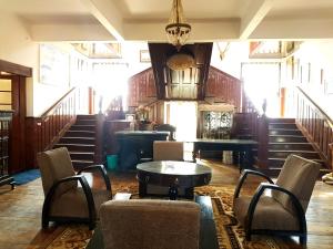 大吉岭Rani Kothi Heritage Residency的配有椅子和桌子的房间以及楼梯