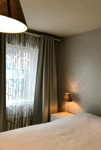 图尔库Apartment in Turku center的一间卧室配有一张床和一扇带灯的窗户
