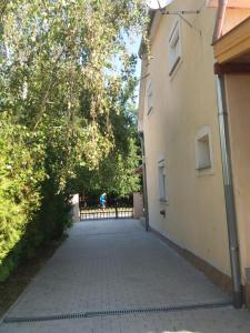 巴拉顿扎佐Sommer Ferienhaus的两栋树木和围栏的建筑之间的人行道