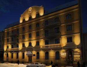 伊万诺-弗兰科夫斯克斯坦尼斯拉维夫酒店的一座大型建筑,前面有停车位