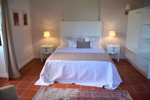 桑塔纳Solar Arco de São Jorge的一间卧室配有一张带2个床头柜的大床