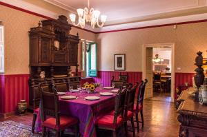 卡尔塔吉罗Affascinante Villa Ottocentesca a Caltagirone的用餐室配有带紫色桌布的桌子