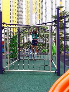 贝克西Apartemen Springlake Summarecon Bekasi-By Bu Johan的一个男孩在操场上玩耍