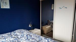 布兰肯贝赫Isola Bella的一间拥有蓝色墙壁、一张床和镜子的卧室