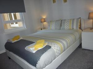 佩斯利Paisley Central Apartment #2的一间卧室配有一张黄色毛巾的床