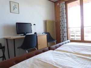 海利根舒文迪贝勒维酒店的一间卧室配有一张床和一张书桌及电视
