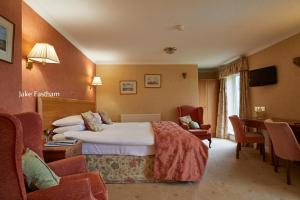 锡德茅斯希德谷乡村别墅酒店的酒店客房带一张床、一张桌子和椅子