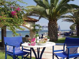 阿凯松扎坎塔海滩酒店的桌椅、桌子和棕榈树