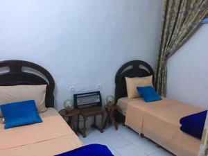 拉巴特达尔卡拉姆旅馆的配有蓝色枕头的客房内的两张床