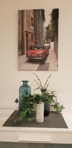 凯撒斯劳滕杜勒斯公寓的一张桌子上一张红车和两株植物的照片