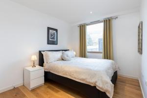 克罗伊登East Croydon Apartments - Just 3 mins walk to East Croydon station的一间卧室设有一张大床和一个窗户。