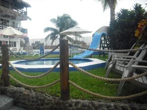 查察拉卡斯Hotel Villas del Rey的一个带滑梯和椅子的游泳池的度假酒店