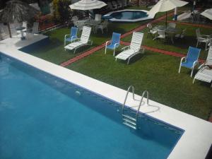 查察拉卡斯Hotel Villas del Rey的一个带桌椅的游泳池和一个游泳池