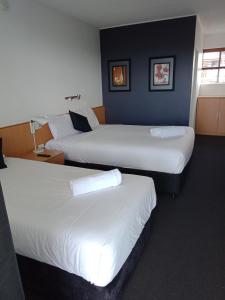 布里斯班安奈尔里汽车旅馆的酒店客房,配有两张带白色床单的床