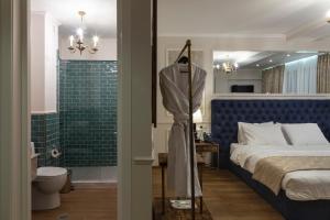 第比利斯Omart Hotel - Gallery的一间卧室配有一张床,浴室设有淋浴。