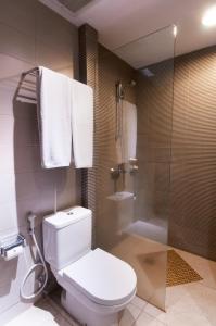 库塔100 Sunset Kuta Hotel & Ballroom的浴室设有卫生间和带毛巾的淋浴。