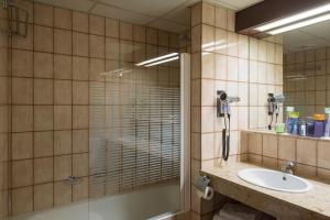 萨拉戈萨戈雅酒店的一间带玻璃淋浴和水槽的浴室