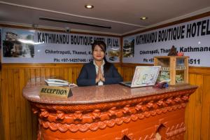 加德满都Kathmandu Boutique Hotel的坐在餐厅柜台的女人