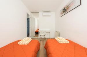 马德里Ever House IFEMA Mar de Cristal的配有桌子的客房内的两张橙色床