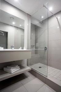 东伦敦奥斯纳酒店的一间带玻璃淋浴和水槽的浴室