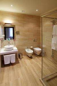 基辅普希亚会议酒店的一间带两个盥洗盆、淋浴和卫生间的浴室