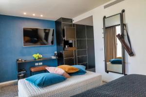 特拉维夫Fabric Hotel - an Atlas Boutique Hotel的一间卧室设有两张带蓝色墙壁和镜子的床
