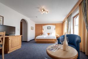 佩尔蒂绍Hotel Alpenrose的酒店客房配有一张床和一张茶几