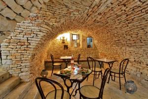 苏亚克Domaine de La Paille Basse的石墙内带桌椅的餐厅