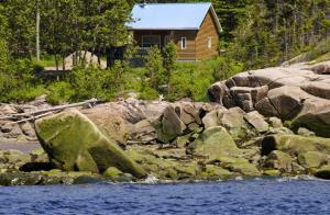 萨克雷克尔萨格奈5星家庭休闲度假村的河岸上的小木屋,有岩石