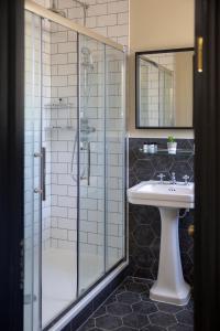 伦敦维多利亚公主酒店的一间带玻璃淋浴和水槽的浴室
