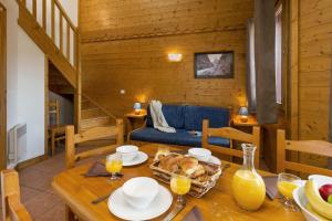 拉普拉涅节日夫人高山牧场小屋酒店的一间带桌子和蓝色沙发的用餐室